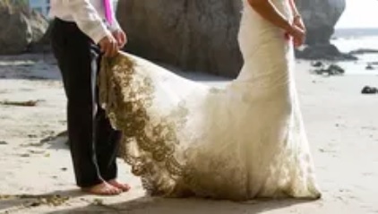 pessoa segurando a barra traseira do vestido da noiva