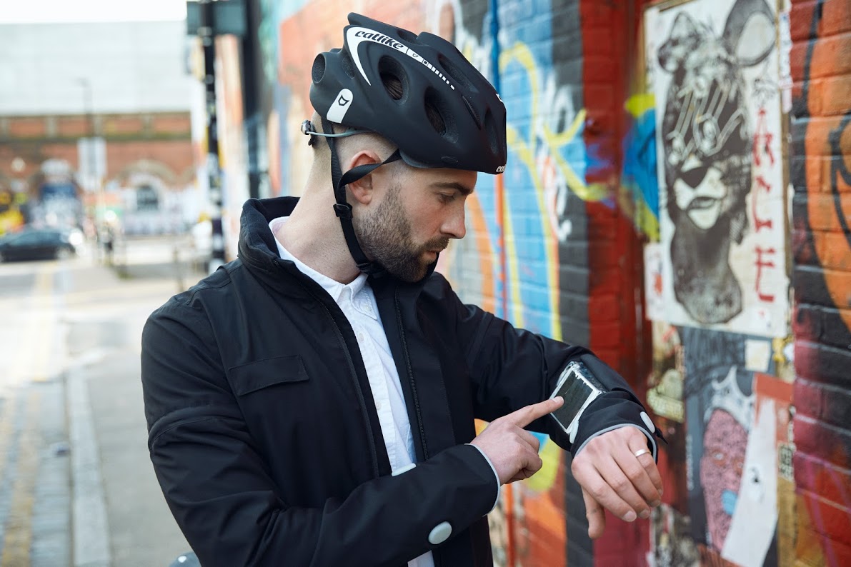 Ciclista digitando no punho da jaqueta inteligente da Ford