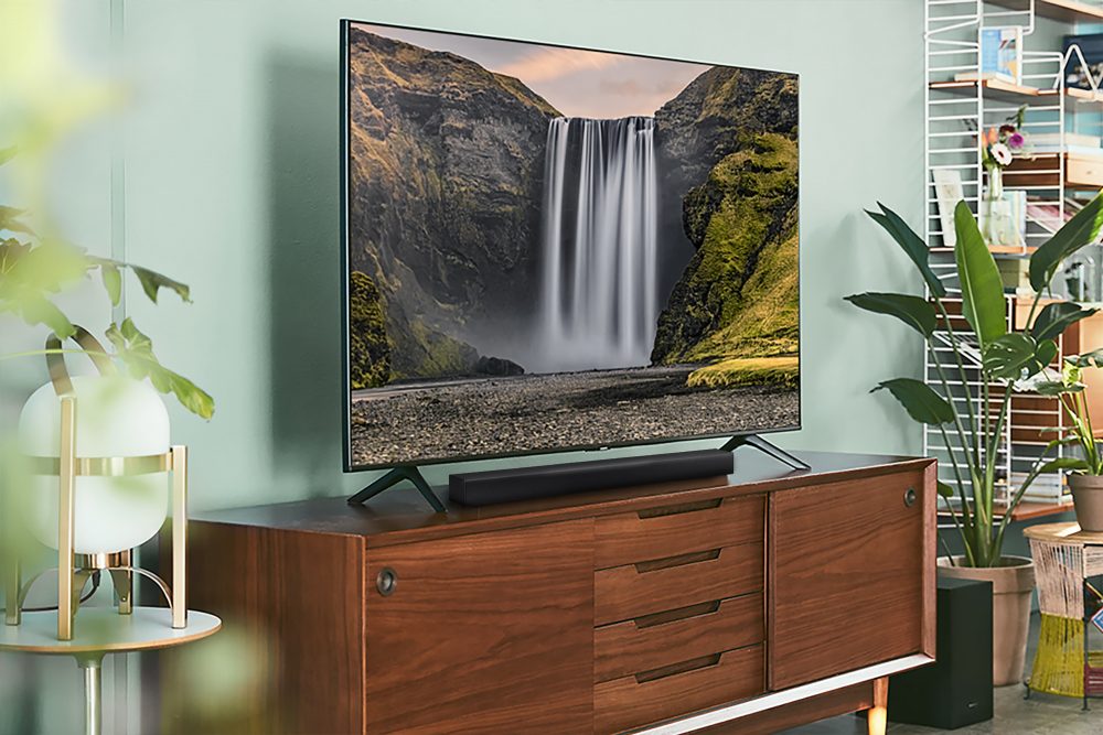 Foto de uma sala de estar com um aparelho Soundbar HW-A455 instalado na TV Samsung