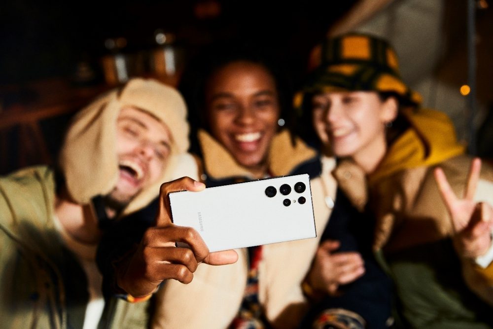 Grupo de jovens tirando selfie com a câmera frontal de um Galaxy S22 5G