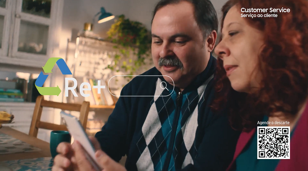 Casal conversando e vendo a tela de um smartphone A50 branco da Samsung